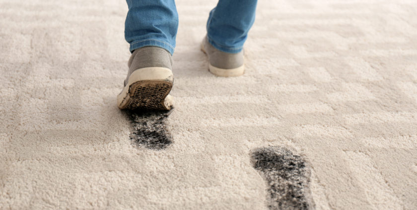 Person in dirty shoes leaving muddy footprints on carpet | Loveland Fort Collins Flooring