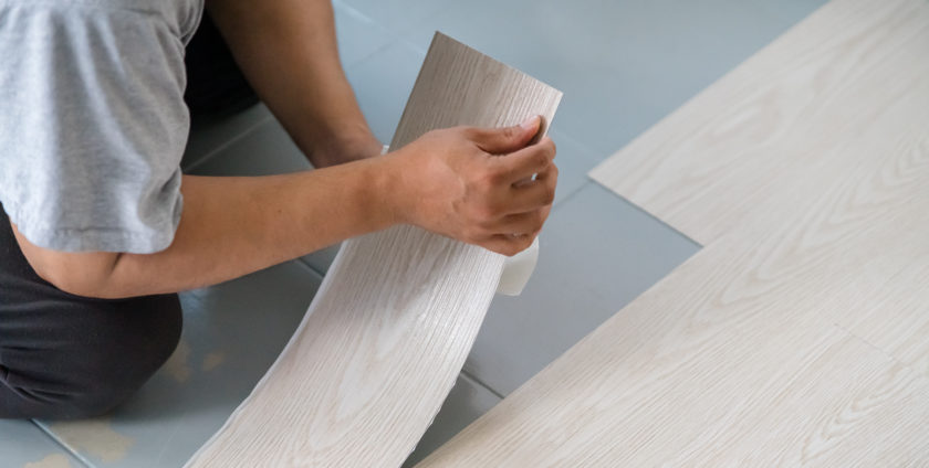 A person installing new vinyl tile floor, a DIY home project | Loveland Fort Collins Flooring