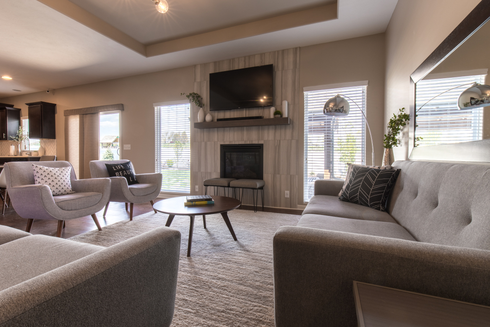 Example of transitional decor with hardwood flooring covered by rug, round table and chairs, fireplace and two sofas. From Graham's Fort Collins Flooring & Design. 