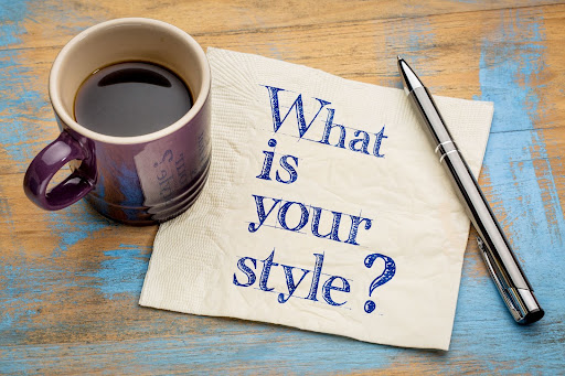 Coffee mug and pen resting on reclaimed wood desk. On a napkin written, "What is your style?" From Graham's Fort Collins Flooring & Design